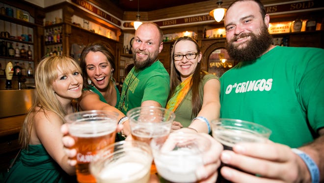 Teman-teman ini mengangkat piala saat Rolla Paula merayakan Hari Santo Patrick pada Kamis 17 Maret di Tempe.