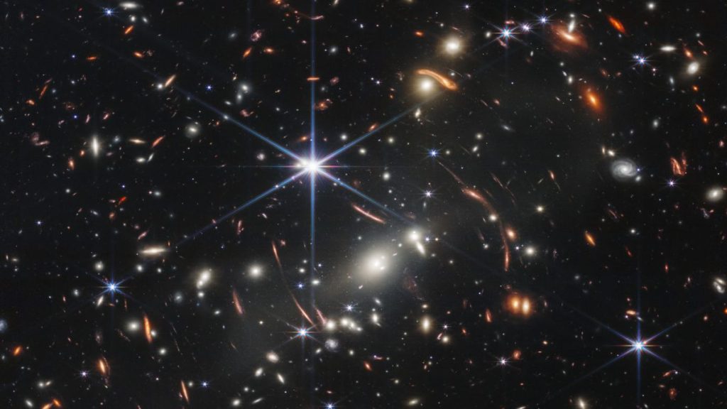 a massive foreground galaxy cluster magnifies and distorts more distant galaxies