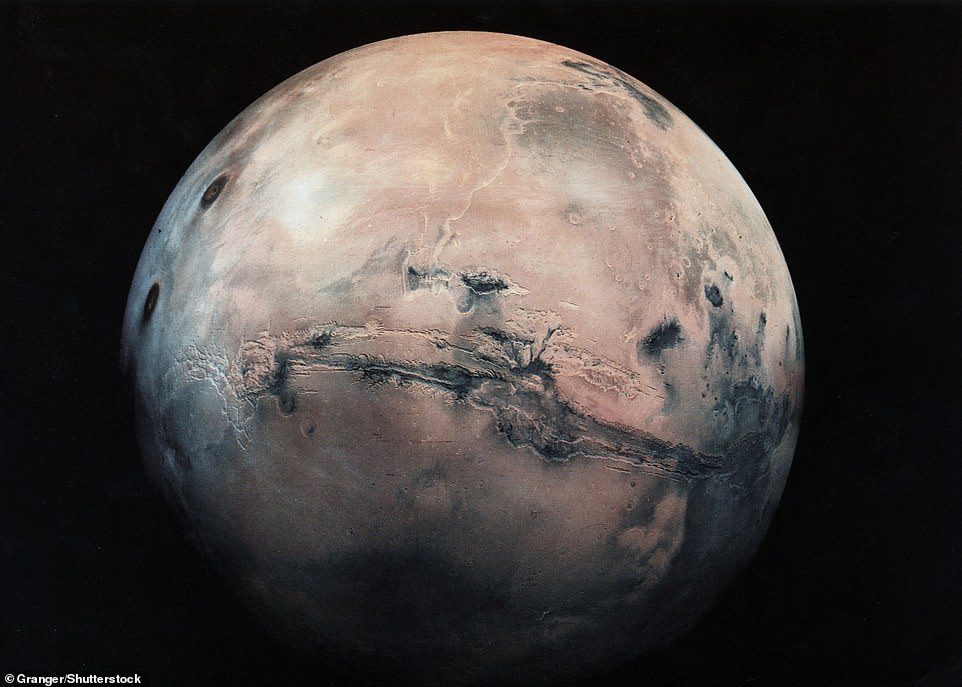 Valles Marineris yang sangat besar di Planet Merah—yang membentang kira-kira seperempat dari keliling planet—terlihat di atas (tengah) dalam gambar ini dari Grup Granger.