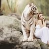 Ini menunjukkan seorang wanita duduk di sebelah harimau putih