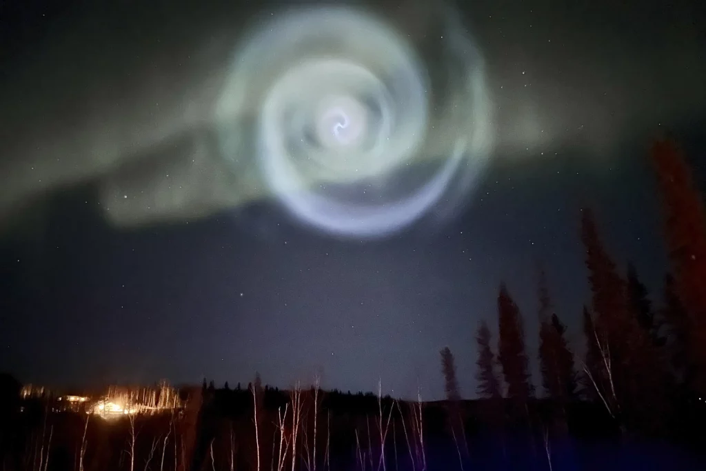 Spiral aneh muncul di tengah cahaya utara di langit malam Alaska