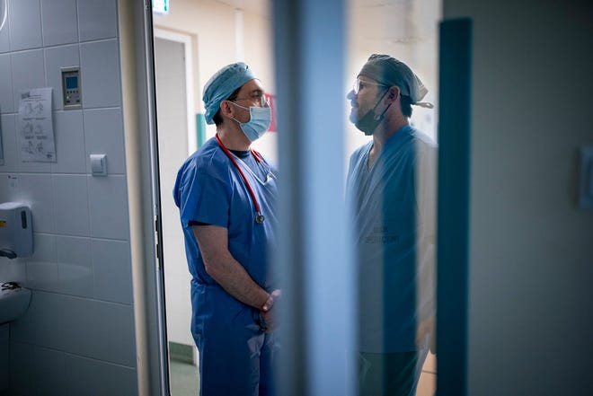 Ahli anestesi Dr. Gennady Vozilov dari Massachusetts berbicara dengan Dr. Sean Diamond, seorang ahli bedah plastik.