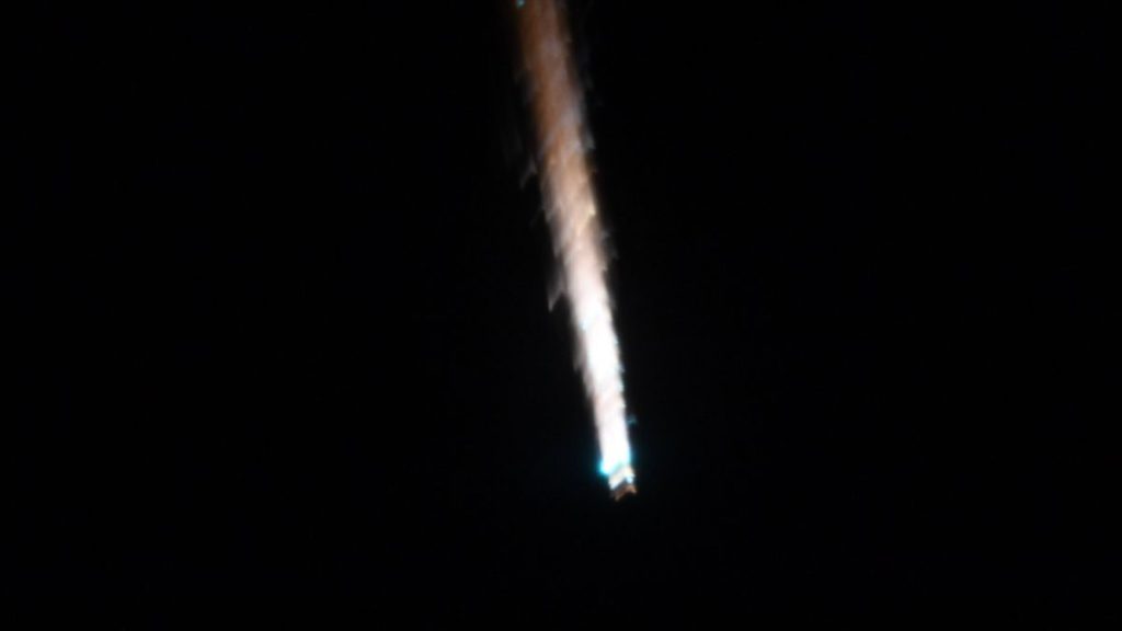 a trail of fire can be seen against a black background