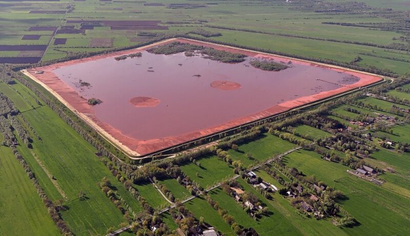 Gambar pemandangan alam yang sebagian besar berwarna hijau dengan area persegi besar berwarna merah di tengahnya.