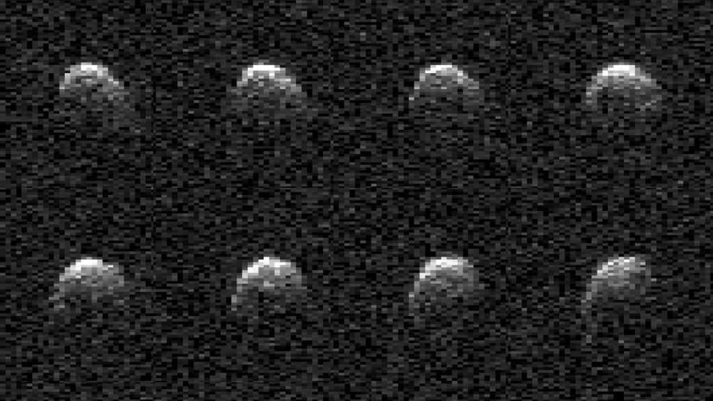 eight grainy images of an oblong rock tumbling in space