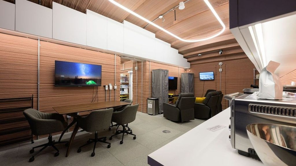 interior of a nasa mock mars base with meeting space, kitchen and futuristic lighting