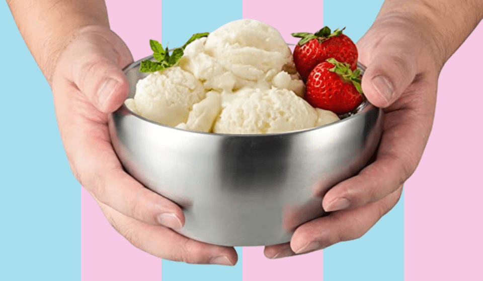 Tangan memegang semangkuk es krim vanilla dan stroberi.