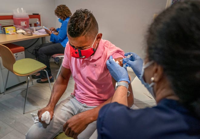 Ever Torres, menerima vaksinasi COVID-19 oleh perawat departemen kesehatan daerah Orlene Grace di Guatemala Maya Center di Lake Worth, Florida pada 13 Agustus 2021.