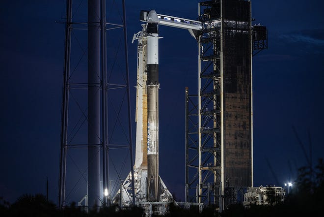 Roket Falcon 9 difoto dengan kapsul SpaceX Dragon yang bertengger di atasnya di Kennedy Space Center di Florida.