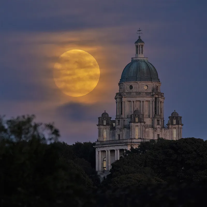 Supermoon di atas Monumen Ashton di Lancaster, Lancashire, Inggris. Foto tersebut diambil oleh Lee Mansfield dari sebuah jembatan sekitar satu mil jauhnya, menggunakan lensa 600mm.