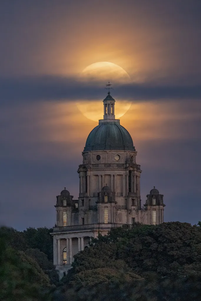 Supermoon di atas Monumen Ashton di Lancaster, Lancashire, Inggris. Foto tersebut diambil oleh Lee Mansfield dari sebuah jembatan sekitar satu mil jauhnya, menggunakan lensa 600mm.