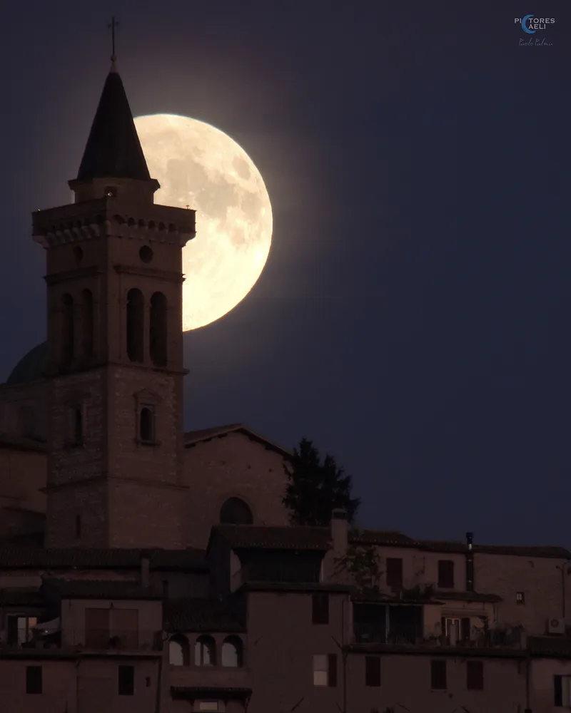 Bulan hampir purnama terbit di atas Basilika San Emiliano, Trevi, Italia, diambil oleh Paolo Palma, 15 September 2024. Perlengkapan: Kamera Nikon Coolpix p510, ISO 400, 1/50 detik.