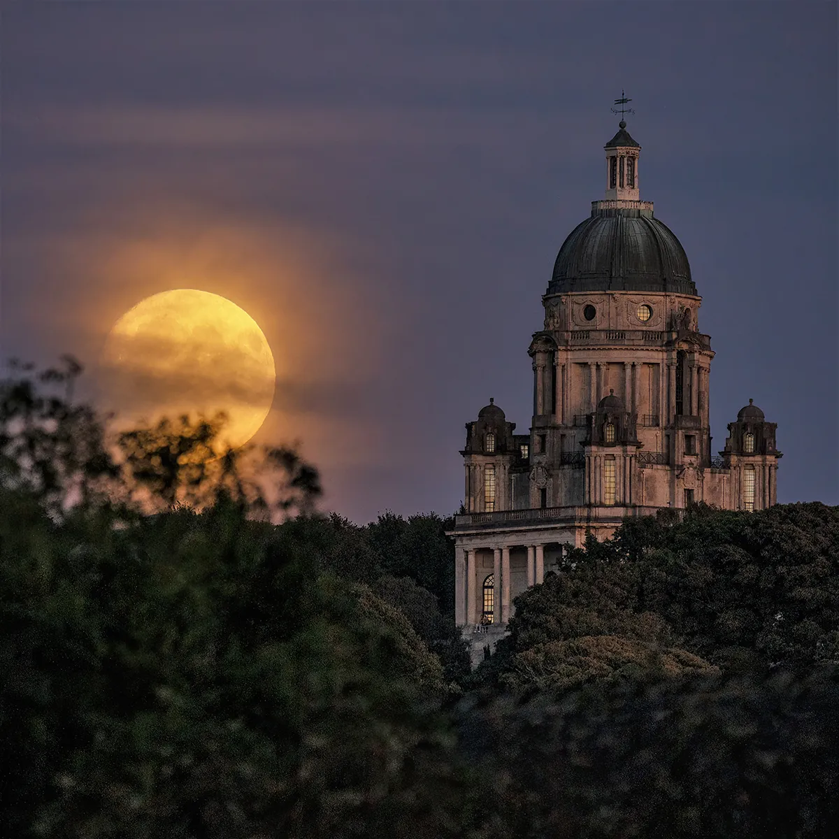 Supermoon di atas Monumen Ashton di Lancaster, Lancashire, Inggris. Foto tersebut diambil oleh Lee Mansfield dari sebuah jembatan sekitar satu mil jauhnya, menggunakan lensa 600mm.